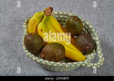 Bio-kaliumreiche Lebensmittel, Avocados, Bananen und Tomaten. Gesunde Sommerkost in einem Leinenkorb!!! Stockfoto