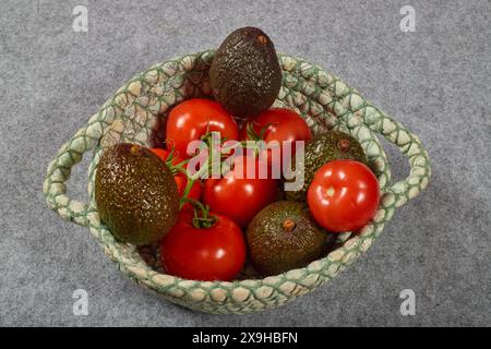 Bio-kaliumreiche Lebensmittel, Avocados, Bananen und Tomaten. Gesunde Sommerkost in einem Leinenkorb!!! Stockfoto