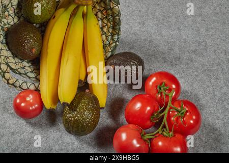 Bio-kaliumreiche Lebensmittel, Avocados, Bananen und Tomaten. Gesunde Sommerkost in einem Leinenkorb!!! Stockfoto