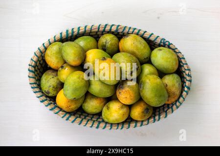 Frische reife Mangos auf einem Korb. Schöner handgefertigter Korb gefüllt mit Reifen Mangos. Draufsicht. Stockfoto