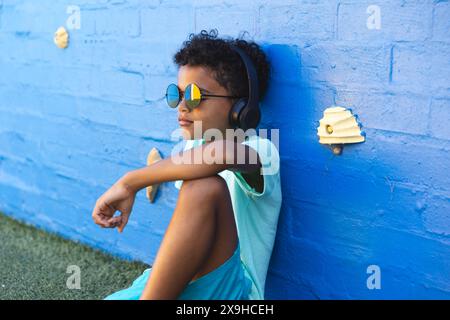 Ein birassischer Junge mit Sonnenbrille genießt Musik im Freien Stockfoto