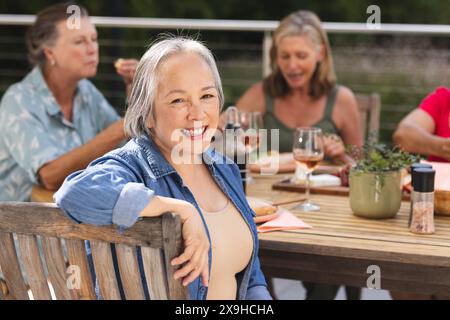Verschiedene ältere Freundinnen, die im Freien essen Stockfoto