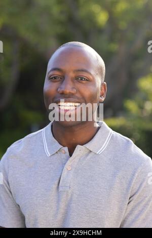 Draußen lächelt der junge Afroamerikaner warm Stockfoto