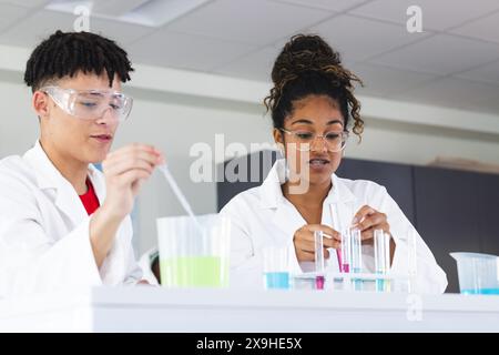 Teenager-birassischer Junge und Teenager-undefiniertes Mädchen in einem Labor in der High School Stockfoto