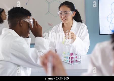 Eine junge birassische Frau führt ein Experiment in einem High School Labor durch Stockfoto