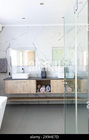 Zu Hause, modernes Badezimmer mit Doppelwaschbecken und Holzschränken Stockfoto