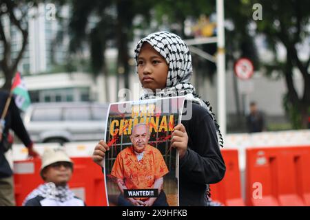 JAKARTA, INDONESIEN - 1. JUNI: Indonesisches Mädchen hält ein Foto von Benjamin Netanjahu während einer pro-palästinensischen Demonstration an der Front der US-Botschaft in Jakarta, Indonesien am 1. Juni 2024 auf. Die Demonstration protestierte gegen den israelischen Militärangriff auf Rafah in Gaza. Stockfoto