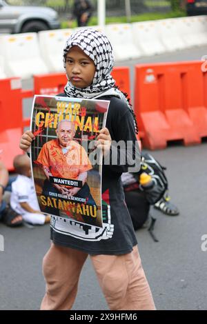 JAKARTA, INDONESIEN - 1. JUNI: Indonesisches Mädchen hält ein Foto von Benjamin Netanjahu während einer pro-palästinensischen Demonstration an der Front der US-Botschaft in Jakarta, Indonesien am 1. Juni 2024 auf. Die Demonstration protestierte gegen den israelischen Militärangriff auf Rafah in Gaza. Stockfoto