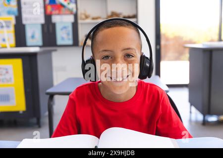 Biracial Boy studiert in einem Klassenzimmer in der Schule bei einem Videoanruf Stockfoto