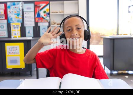 Biracial Boy genießt eine Lerneinheit in der Schule bei einem Videoanruf Stockfoto