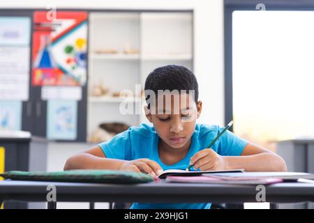 Birassischer Junge konzentrierte sich auf seine Schularbeit im Klassenzimmer Stockfoto