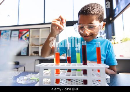 Ein birassischer Junge macht an einem wissenschaftlichen Experiment in der Schule Teil Stockfoto