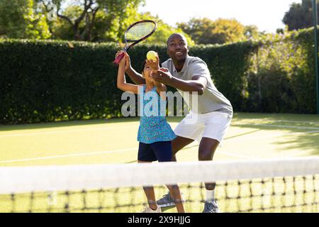 Im Freien spielen Vater und Tochter an sonnigen Tagen Tennis Stockfoto