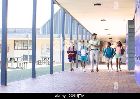 In der Schule laufen verschiedene Gruppen von Schülern mit ihrem Lehrer Stockfoto