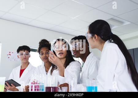 Verschiedene Schüler beteiligen sich an einem wissenschaftlichen Experiment an der High School Stockfoto