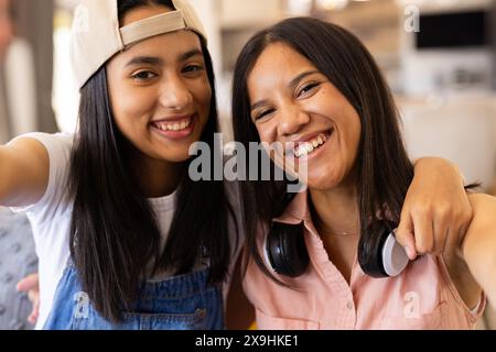 Birassische junge Schwestern zu Hause, die Selfie in lässigen Outfits machen Stockfoto