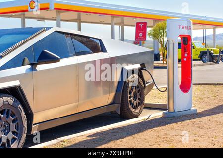 White Hills, Arizona - 14. April 2024: Tesla Cybertruck Elektrofahrzeug wird an einer Supercharger Station aufgeladen Stockfoto