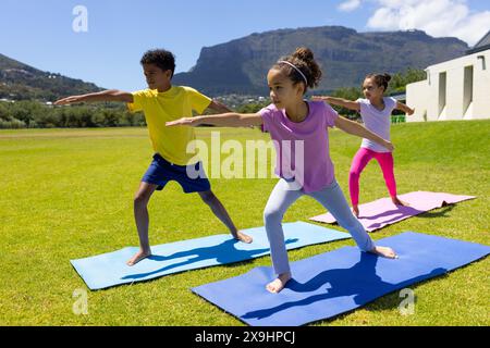 Birassische Kinder üben an einem sonnigen Tag im Freien Yoga Stockfoto