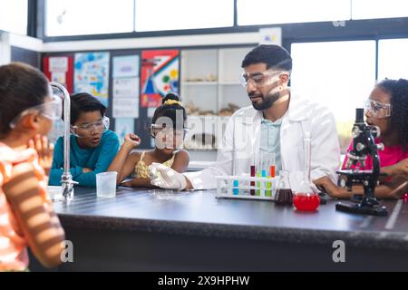 Ein junger asiatischer Lehrer zeigt Experimente Stockfoto