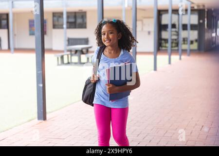 Biracial Girl steht selbstbewusst in der Schule, mit Kopierraum Stockfoto