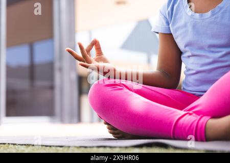 Biracial Girl praktiziert Yoga zu Hause, mit Kopierraum Stockfoto