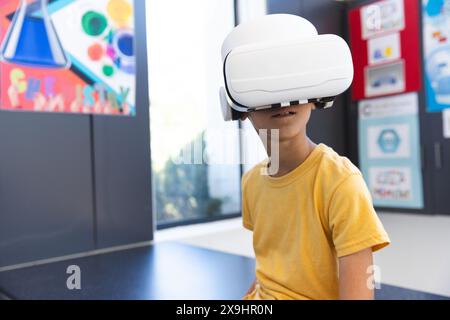 Biracial Boy erforscht die virtuelle Realität in einem Klassenzimmer in der Schule Stockfoto