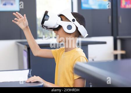 Biracial Boy erforscht die virtuelle Realität in einem Klassenzimmer Stockfoto