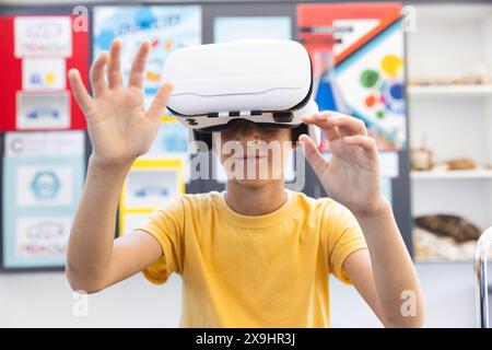 Biracial Boy erforscht die virtuelle Realität in einem Klassenzimmer in der Schule Stockfoto