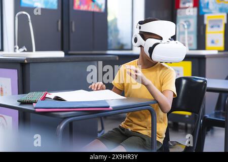 Biracial Boy erforscht die virtuelle Realität in einem Klassenzimmer in der Schule Stockfoto