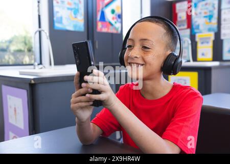 Biracial Boy genießt Technologie in der Schule mit einem Tablet Stockfoto