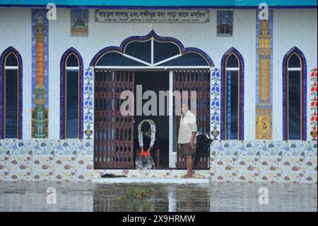 Sylhet, Bangladesch. 30. Mai 2024. Eine Person versucht, Wasser aus einer Moschee in der Gegend von Rangpani auf Sylhets Tamabil-Straße in Jaintapur upazila zu entfernen. Starke Regenfälle vom Zyklon Remal verursachten Überschwemmungen aus den Bergen von Meghalaya, die Jaintapur, Goainghat, Kanaighat und Jakiganj upazilas überschwemmten und etwa drei Seenopfer einsperrten. Stockfoto