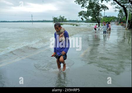 Sylhet, Bangladesch. 30. Mai 2024. Ältere Bewohner kämpfen darum, durch die überflutete Hauptstraße im Lafnaut-Gebiet von Sylhets Gowainghat upazila zu waten. Der anhaltende Regen vom Zyklon Remal hat dazu geführt, dass Wasser aus den umliegenden Hügeln herabströmt und die Straße seit gestern überschwemmt. Es wird festgestellt, dass viele Menschen ihre Häuser verlassen und in sichere Unterkünfte gegangen sind. Die tief liegenden und Hasengebiete von drei Gewerkschaften in Sylhets Jaintapur upazila wurden durch Sturzfluten überschwemmt, die durch starke Regenfälle und Wasser von Berghängen ausgelöst wurden. Rund 300 000 Menschen in vier upazilas sind im Wasser gefangen Stockfoto