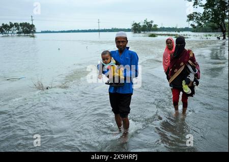 Sylhet, Bangladesch. 30. Mai 2024. In der Barhal-Gegend von Goainghat upazila wurden viele Häuser von Überschwemmungen überschwemmt, was die Bewohner zwang, woanders mit ihren Rindern und Geflügel Zuflucht zu suchen. Starke Regenfälle vom Zyklon Remal haben Überschwemmungen aus den Bergen von Meghalaya verursacht, indem sie Jaintapur, Goainghat, Kanaighat und Jakiganj upazilas überschwemmen und etwa drei Menschen am See einsperren. Stockfoto