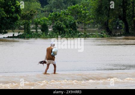Sylhet, Bangladesch. 30. Mai 2024. Ältere Bewohner kämpfen darum, durch die überflutete Hauptstraße im Lafnaut-Gebiet von Sylhets Gowainghat upazila zu waten. Der anhaltende Regen vom Zyklon Remal hat dazu geführt, dass Wasser aus den umliegenden Hügeln herabströmt und die Straße seit gestern überschwemmt. Es wird festgestellt, dass viele Menschen ihre Häuser verlassen und in sichere Unterkünfte gegangen sind. Die tief liegenden und Hasengebiete von drei Gewerkschaften in Sylhets Jaintapur upazila wurden durch Sturzfluten überschwemmt, die durch starke Regenfälle und Wasser von Berghängen ausgelöst wurden. Rund 300 000 Menschen in vier upazilas sind im Wasser gefangen Stockfoto