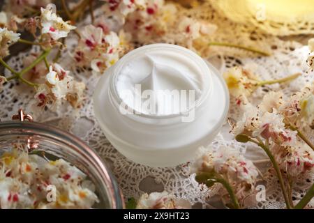 Hausgemachte Rosskastaniencreme in einem Glasgefäß mit Freh Aesculus hippocastanum-Blüten, die im Frühjahr geerntet werden Stockfoto