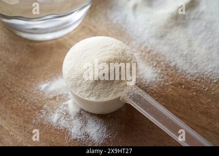 Kollagenpulver in einem Plastik-Messlöffel auf einem Tisch, Nahaufnahme Stockfoto