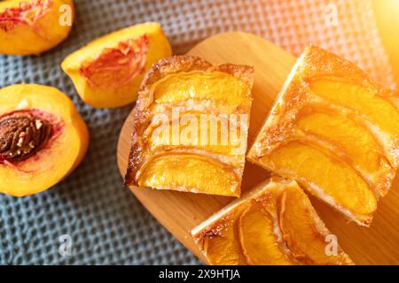 Ein Dessert aus geschnittenen Pfirsichen ist auf einem hölzernen Schneidebrett. Das Dessert ist mit Zucker bedeckt und sieht köstlich aus. Stockfoto