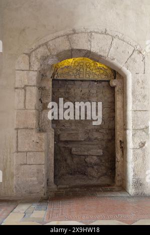 Wien, Österreich. Die Michaelerkirche ist eine römisch-katholische Pfarrkirche am Michaelerplatz in Wien. Der romanische Eingang ist ummauert. Romanisches Tympanum (um 1245) Stockfoto