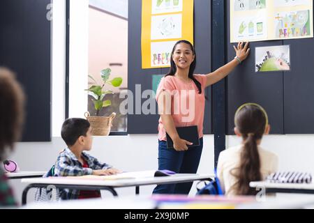 Eine birassische junge Lehrerin unterrichtet aufmerksame Schüler in einem Klassenzimmer Stockfoto