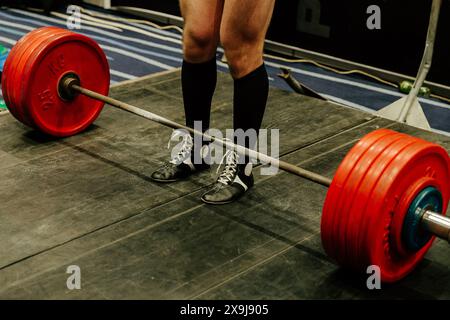 Deadlift-Übung beim Powerlifting-Wettkampf, Beine Mann in schwarzen Kniestrümpfen Stockfoto