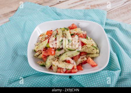 Türkischer Coban (Choban) Salate oder Schäfersalat in weißer Schüssel. Türkischer Schäfersalat mit Gurke, Tomate, roten Zwiebeln, Pfeffer, Petersilie. Stockfoto