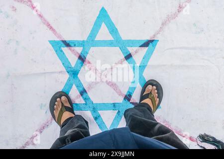 Fußgänger treten während einer pro-palästinensischen Demonstration „All Eyes on Rafah“ in Bogor, West-Java, Indonesien, am 1. Juni 2024 auf eine israelische Flagge. Stockfoto