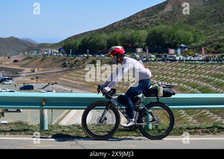 (240601) -- USU, 1. Juni 2024 (Xinhua) -- Ein Radfahrer fährt mit dem Fahrrad zum Duku Highway in Usu City, nordwestchinesischer Autonomen Region Xinjiang Uygur, 1. Juni 2024. Der Duku Highway, einer der schönsten Straßen Chinas, nahm seinen Betrieb am Samstag nach einer jährlichen Wintersperrung wieder auf, die normalerweise im Oktober beginnt. In diesem Jahr nahm der Verkehr auf der 560 km langen Autobahn früher wieder auf als in den letzten fünf Jahren. Die Autobahn verbindet Dushanzi im Norden der Autonomen Region Xinjiang Uygur mit der Stadt Kuqa im Süden und verläuft durch verschiedene Landschaften wie Gletscher, Wälder und Grasland. Stockfoto