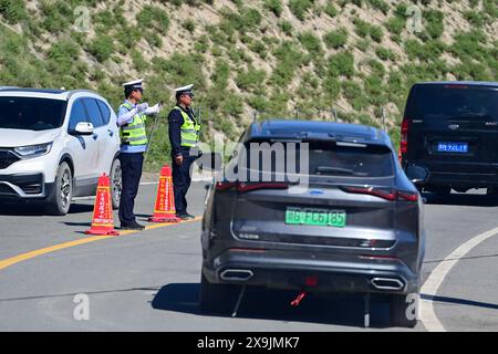 (240601) -- USU, 1. Juni 2024 (Xinhua) -- die Verkehrspolizei ist im Dienst in einem Servicegebiet entlang des Duku Highway in Usu City, nordwestchinesischer Autonomen Region Xinjiang Uygur, 1. Juni 2024. Der Duku Highway, einer der schönsten Straßen Chinas, nahm seinen Betrieb am Samstag nach einer jährlichen Wintersperrung wieder auf, die normalerweise im Oktober beginnt. In diesem Jahr nahm der Verkehr auf der 560 km langen Autobahn früher wieder auf als in den letzten fünf Jahren. Die Autobahn, die Dushanzi im Norden der Autonomen Region Xinjiang Uygur und Kuqa im Süden verbindet, verläuft durch verschiedene Landschaften, darunter Gletscher, Stockfoto