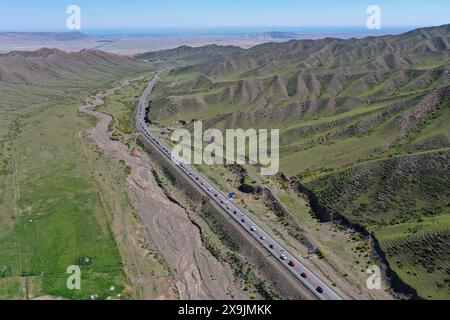 (240601) -- USU, 1. Juni 2024 (Xinhua) -- ein Luftdrohnenfoto vom 1. Juni 2024 zeigt Fahrzeuge, die auf den Duku Highway in Usu City, Nordwestchinas Autonomous Region Xinjiang Uygur, aufbrechen. Der Duku Highway, einer der schönsten Straßen Chinas, nahm seinen Betrieb am Samstag nach einer jährlichen Wintersperrung wieder auf, die normalerweise im Oktober beginnt. In diesem Jahr nahm der Verkehr auf der 560 km langen Autobahn früher wieder auf als in den letzten fünf Jahren. Die Autobahn verbindet Dushanzi im Norden der Autonomen Region Xinjiang Uygur mit der Stadt Kuqa im Süden und verläuft durch verschiedene Landschaften, darunter auch Stockfoto