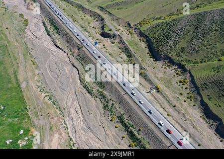 (240601) -- USU, 1. Juni 2024 (Xinhua) -- ein Luftdrohnenfoto vom 1. Juni 2024 zeigt Fahrzeuge, die auf den Duku Highway in Usu City, Nordwestchinas Autonomous Region Xinjiang Uygur, aufbrechen. Der Duku Highway, einer der schönsten Straßen Chinas, nahm seinen Betrieb am Samstag nach einer jährlichen Wintersperrung wieder auf, die normalerweise im Oktober beginnt. In diesem Jahr nahm der Verkehr auf der 560 km langen Autobahn früher wieder auf als in den letzten fünf Jahren. Die Autobahn verbindet Dushanzi im Norden der Autonomen Region Xinjiang Uygur mit der Stadt Kuqa im Süden und verläuft durch verschiedene Landschaften, darunter auch Stockfoto