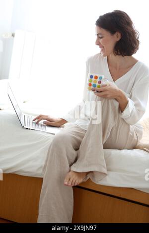 Frau, die einen Laptop benutzt und lächelt. Stockfoto