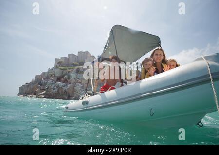 Familie mit Kindern macht eine Bootsfahrt in der Nähe eines Schlosses Peniscola, S Stockfoto