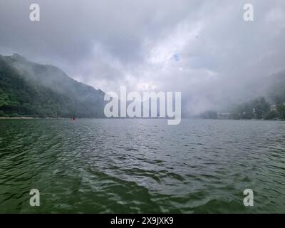 Ruhiges Wasser und grüne Hügel mit sanftem Nebel über den Seen von bhimtal nainital, die einen wunderschönen Bergstation Urlaubsort zeigen Stockfoto