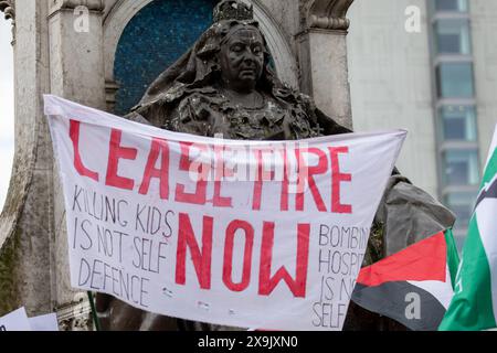 „Waffenstillstand jetzt“-Banner auf dem Victoria Monument Piccadilly. Palästinensische Demonstration. Palästinensische Demonstration im Stadtzentrum von Manchester. Der Protest sah Demonstranten die Marktstraße entlang an einer Filiale der Barclays Bank vorbeiziehen, die nach dem Zerschlagen von Fenstern an Bord ging und das Gebäude mit roter Farbe bedeckt war, als Teil eines Protestes gegen die Beteiligung der Banken an Investitionen in Israel. Manchester, UK Bild: Garyroberts/worldwidefeatures.com Stockfoto